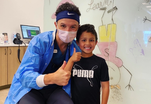 Pediatric dentist and patient giving thumbs up