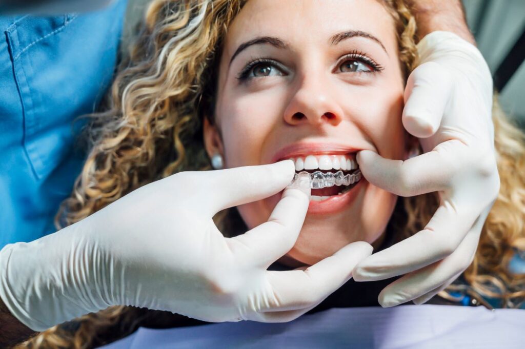 A dentist putting on a patient’s clear aligners.